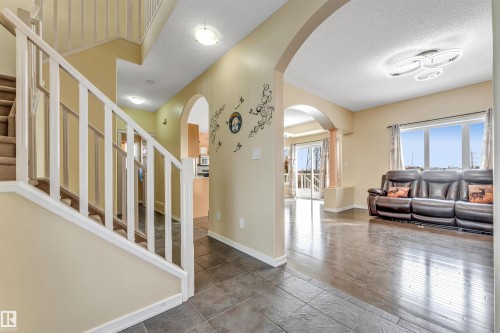 Foyer entrance featuring a textured ceiling, arched walkways, and wood finished floors - 3449 28 Street, Edmonton, AB - Indoor Photo Showing Other Room