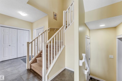 Stairway with a textured ceiling and baseboards - 3449 28 Street, Edmonton, AB - Indoor Photo Showing Other Room