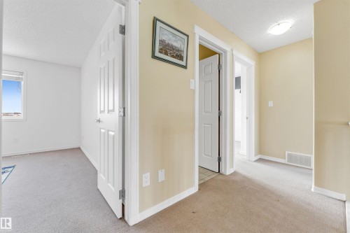 Corridor featuring a textured ceiling and light colored carpet - 3449 28 Street, Edmonton, AB - Indoor Photo Showing Other Room