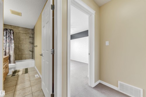Hall with a textured ceiling, light tile patterned floors, and light carpet - 3449 28 Street, Edmonton, AB - Indoor Photo Showing Other Room