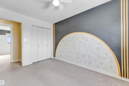 Unfurnished bedroom with a closet, carpet floors, a ceiling fan, and a textured ceiling - 3449 28 Street, Edmonton, AB - Indoor Photo Showing Other Room