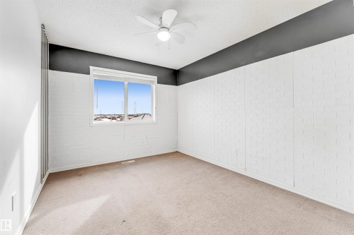 Unfurnished room with light carpet, ceiling fan, and a textured ceiling - 3449 28 Street, Edmonton, AB - Indoor Photo Showing Other Room