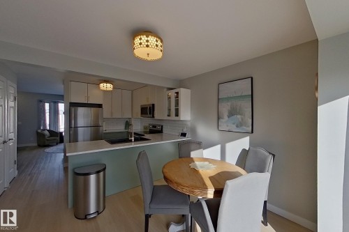 Kitchen with light countertops, stainless steel appliances, decorative backsplash, light wood-type flooring, and a peninsula - 121 1 Aberdeen Way, Stony Plain, AB - Indoor