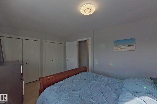 Bedroom featuring multiple closets and wood finished floors - 121 1 Aberdeen Way, Stony Plain, AB - Indoor Photo Showing Bedroom