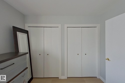 Unfurnished bedroom featuring multiple closets and light wood-style flooring - 121 1 Aberdeen Way, Stony Plain, AB - Indoor