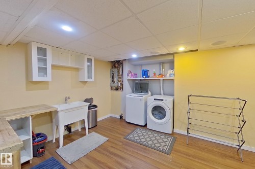 Laundry area with a drop ceiling, washer and clothes dryer, light wood-type flooring, recessed lighting, and electric panel - 121 1 Aberdeen Way, Stony Plain, AB - Indoor Photo Showing Laundry Room