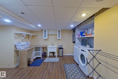 Laundry area featuring recessed lighting, a paneled ceiling, dark wood-type flooring, and washer and dryer - 121 1 Aberdeen Way, Stony Plain, AB - Indoor