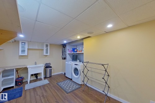 Laundry area with a paneled ceiling, recessed lighting, dark wood-type flooring, independent washer and dryer, and electric panel - 121 1 Aberdeen Way, Stony Plain, AB - Indoor