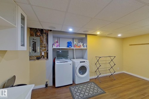 Laundry area featuring a drop ceiling, electric panel, independent washer and dryer, wood finished floors, and recessed lighting - 121 1 Aberdeen Way, Stony Plain, AB - Indoor Photo Showing Laundry Room