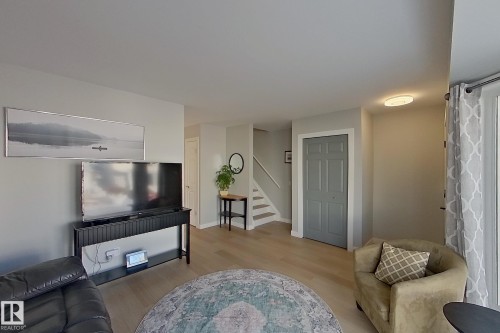 Living area featuring stairs and light wood-style flooring - 121 1 Aberdeen Way, Stony Plain, AB - Indoor Photo Showing Living Room