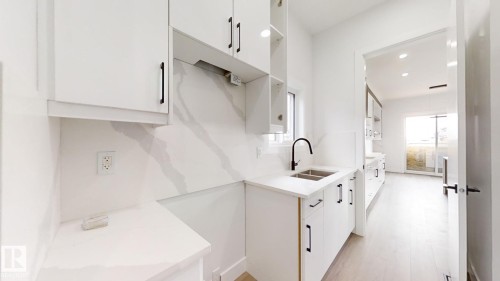 Kitchen with white cabinetry, light wood-type flooring, light stone counters, recessed lighting, and modern cabinets - 1707 18 Street, Edmonton, AB - Indoor Photo Showing Kitchen With Double Sink