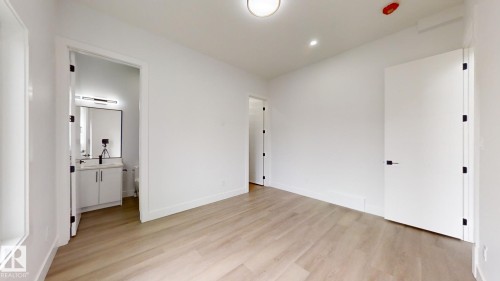 Unfurnished bedroom with light wood-style flooring and ensuite bath - 1707 18 Street, Edmonton, AB - Indoor Photo Showing Other Room