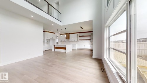 Unfurnished living room featuring light wood-style flooring, a towering ceiling, and recessed lighting - 1707 18 Street, Edmonton, AB - Indoor