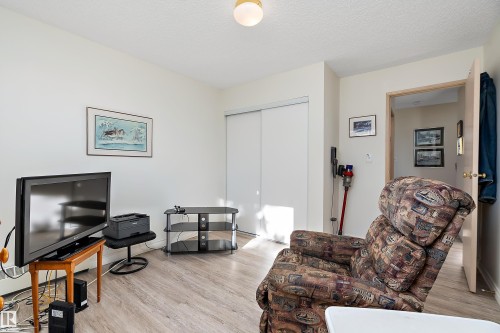 Living area featuring light wood finished floors and a textured ceiling - 116 11620 9A Avenue, Edmonton, AB - Indoor Photo Showing Living Room