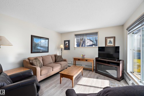 Living room featuring light flooring and sliding patio doors - 116 11620 9A Avenue, Edmonton, AB - Indoor Photo Showing Living Room