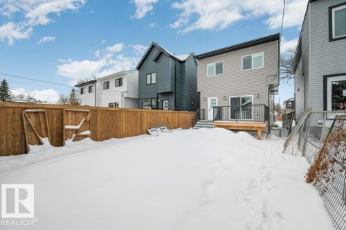 Snow covered property featuring a fenced backyard and a deck - Edmonton, AB - Outdoor