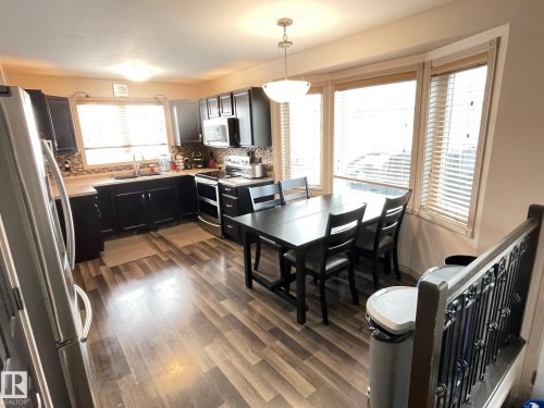 Kitchen with stainless steel appliances, light countertops, dark wood-type flooring, dark cabinetry, and tasteful backsplash - 324 Warwick Road, Edmonton, AB - Indoor