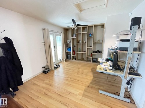 Office area in the primary bedroom with light wood-style flooring, a ceiling fan, and a textured ceiling - 324 Warwick Road, Edmonton, AB - Indoor Photo Showing Gym Room