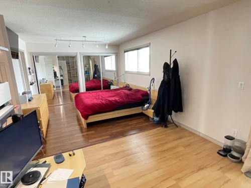 Bedroom featuring a textured ceiling, light wood-type flooring, and rail lighting - 324 Warwick Road, Edmonton, AB - Indoor Photo Showing Bedroom