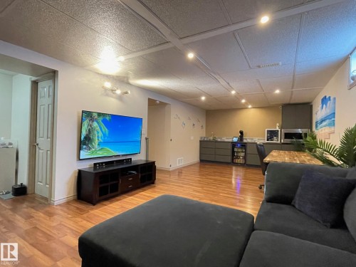 Living room with light wood-style floors, beverage cooler, wet bar, and recessed lighting - 324 Warwick Road, Edmonton, AB - Indoor