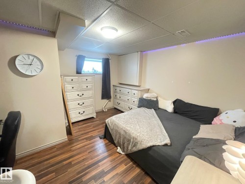 Bedroom in basement with dark wood finished floors and a paneled ceiling - 324 Warwick Road, Edmonton, AB - Indoor Photo Showing Bedroom