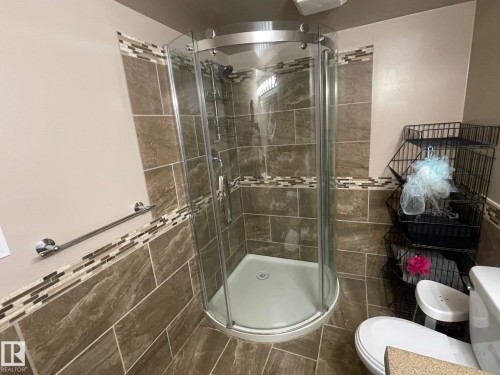 Full bath with tile walls, a stall shower, and wainscoting - 324 Warwick Road, Edmonton, AB - Indoor Photo Showing Bathroom
