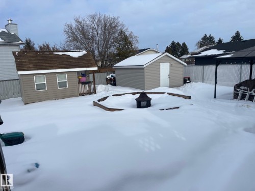 Yard covered in snow with a fenced backyard and a storage unit - 324 Warwick Road, Edmonton, AB - Outdoor