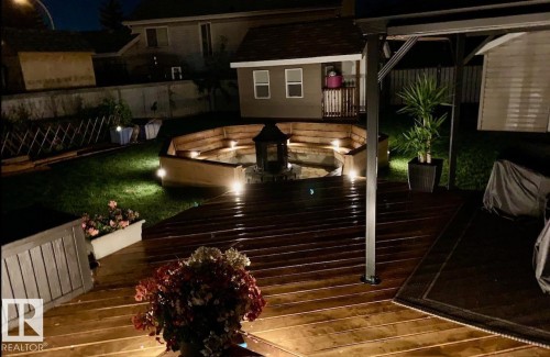 Deck at twilight that has fully lighting for entertaining and a fenced backyard, a storage shed, and outdoor dining space - 324 Warwick Road, Edmonton, AB - Outdoor With Deck Patio Veranda With Exterior