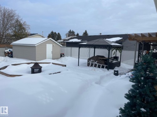 Snowy yard with a fenced backyard, a fire pit, an outdoor structure, and a gazebo - 324 Warwick Road, Edmonton, AB - Outdoor