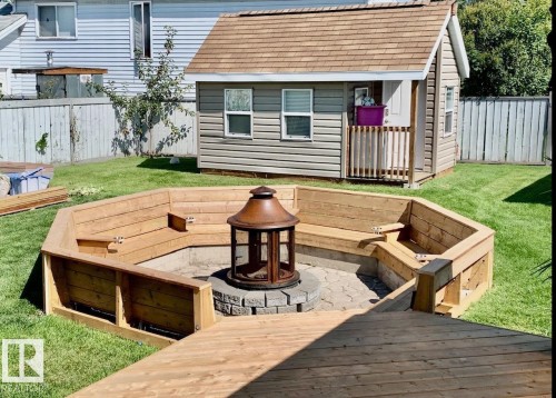 Huge 18' 20' Wooden terrace with a fenced backyard and a Sun-kin fire pit. Check out this "REAL" She-Shed that’s  insulated, heated with power and internet fantastic for any hobbiest. - 324 Warwick Road, Edmonton, AB - Outdoor With Deck Patio Veranda With Exterior