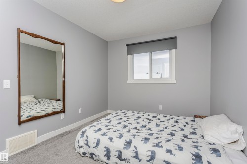 Bedroom with light carpet and baseboards - 16420 15 Avenue, Edmonton, AB - Indoor Photo Showing Bedroom