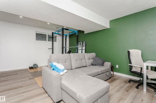 Home office with light wood-style flooring and a textured ceiling - 16420 15 Avenue, Edmonton, AB - Indoor