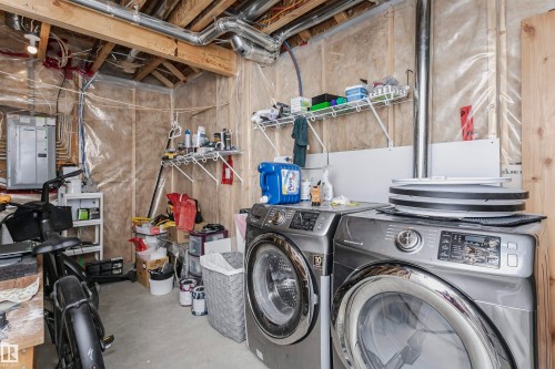 Laundry area with concrete flooring, electric panel, and washer and clothes dryer - 16420 15 Avenue, Edmonton, AB - Indoor Photo Showing Laundry Room