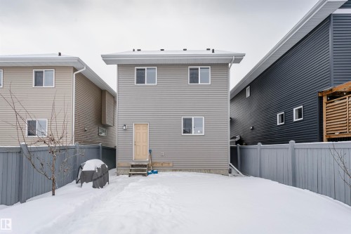 Snow covered house with a fenced backyard and entry steps - 16420 15 Avenue, Edmonton, AB - Outdoor With Exterior