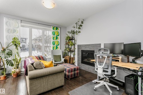 Office area featuring dark wood finished floors and a fireplace - 16420 15 Avenue, Edmonton, AB - Indoor Photo Showing Office