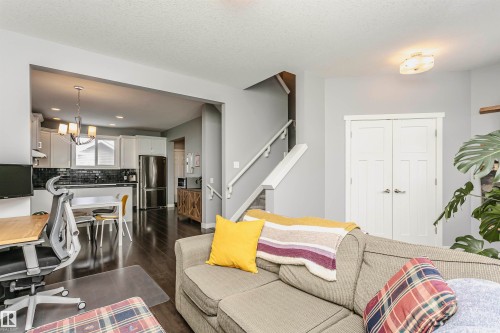 Living area with dark wood finished floors and a chandelier - 16420 15 Avenue, Edmonton, AB - Indoor