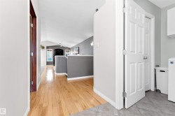 Hallway featuring vaulted ceiling, washer / clothes dryer, and light wood-type flooring - 
