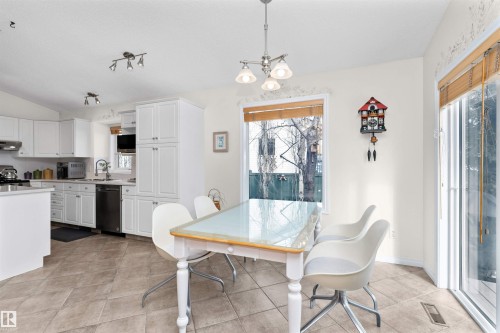 Dining room featuring healthy amount of natural light, lofted ceiling, suspended lighting, and light tile patterned floors - 357 Blackburn Drive E, Edmonton, AB - Indoor