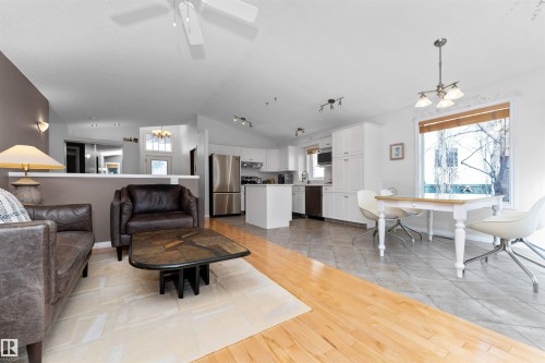 Living room featuring suspended lighting, light wood-style floors, and a ceiling fan - 357 Blackburn Drive E, Edmonton, AB - Indoor