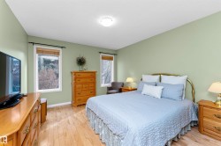 Bedroom with light wood-type flooring and multiple windows - 