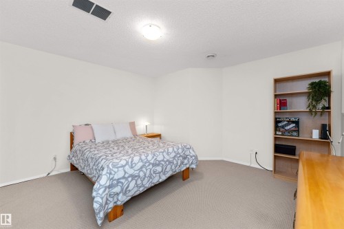 Carpeted bedroom featuring a textured ceiling and baseboards - 357 Blackburn Drive E, Edmonton, AB - Indoor Photo Showing Bedroom