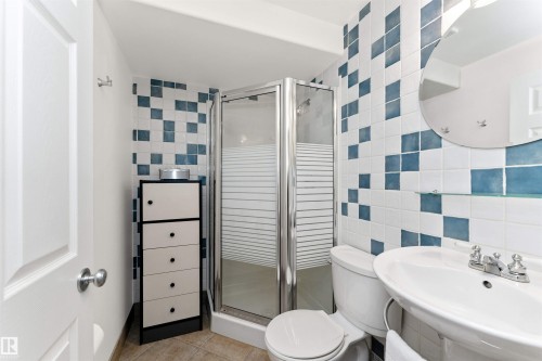 Bathroom featuring tile walls, a stall shower, and light tile patterned flooring - 357 Blackburn Drive E, Edmonton, AB - Indoor Photo Showing Bathroom