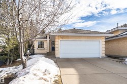Single story home with a garage, stucco siding, driveway, and a tiled roof - 