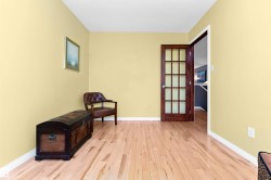 Living area with light wood-type flooring and baseboards - 