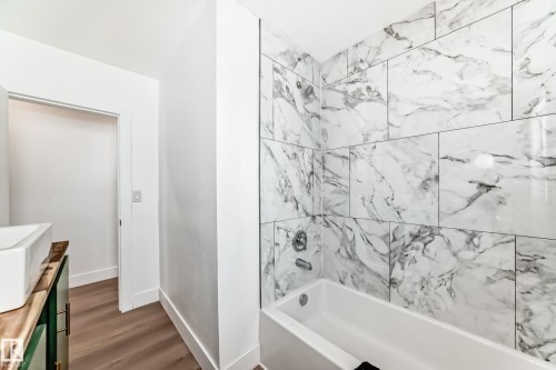 Full bathroom with vanity, shower / washtub combination, and dark wood-style floors - 8712 89 Avenue, Edmonton, AB - Indoor Photo Showing Bathroom