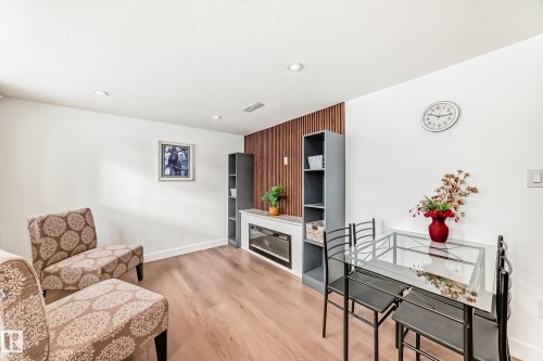 Living area with light wood-type flooring and recessed lighting - 8712 89 Avenue, Edmonton, AB - Indoor Photo Showing Living Room With Fireplace