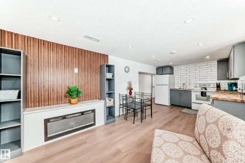 Living area with light wood finished floors and recessed lighting - 8712 89 Avenue, Edmonton, AB - Indoor Photo Showing Living Room With Fireplace