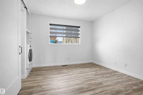 Laundry room with a barn door, light wood-type flooring, and washer / dryer - 4204 41B Street, Leduc, AB - Indoor Photo Showing Other Room