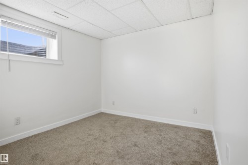Carpeted empty room with baseboards and a drop ceiling - 4204 41B Street, Leduc, AB - Indoor Photo Showing Other Room