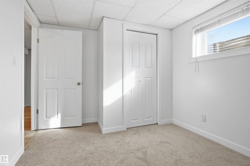 Unfurnished bedroom featuring light colored carpet, a drop ceiling, and a closet - 4204 41B Street, Leduc, AB - Indoor Photo Showing Other Room